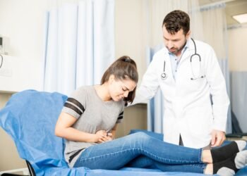 beautiful young woman having severe stomach ache visiting doctor treatment 1 1